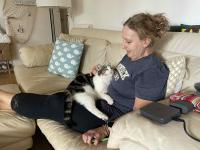 Leo ilooks up lovingly at Kath while snuggling on her lap