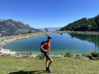 Diana hikes in front of a limpid, azure pond