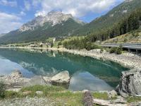 The road arcs along the lake near Sufers